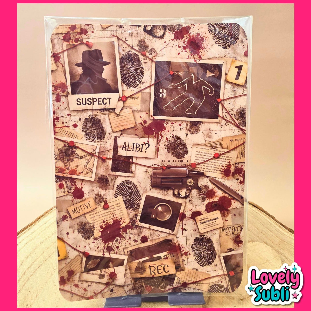 A rectangular wall art print or poster featuring a collage of western-crime-themed elements, including a silhouette in a hat labeled 'SUSPECT', a running man silhouette, fingerprints, blood splatters, small photo frames, and a revolver. The print is photographed hanging against a beige wall with a pink border around the image.