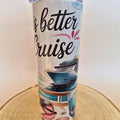 A white insulated tumbler with a travel-themed print that reads 'is better Cruise' in black script, featuring an illustration of a cruise ship, ocean waves, and beach accessories, standing on a round wooden slice against a plain light background.