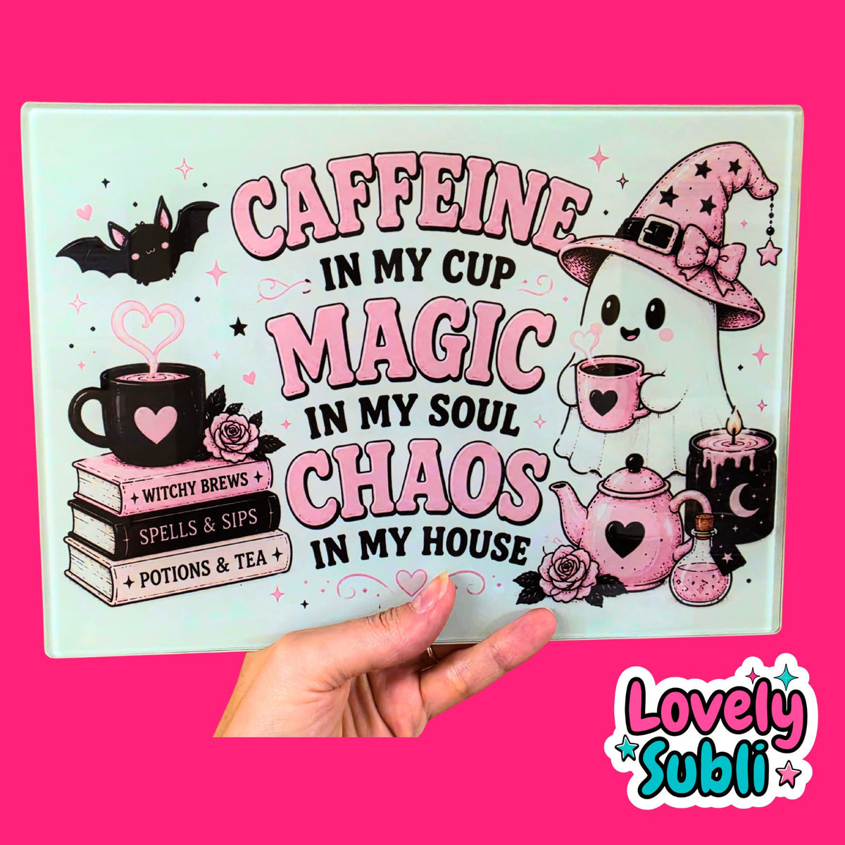 A rectangular decorative sign with a whimsical coffee-and-magic theme, held by a hand against a bright pink background. The sign features the text 'CAFFEINE IN MY CUP MAGIC IN MY SOUL CHAOS IN MY HOUSE' with illustrations of a witch ghost, a teapot, a mug, books, and a bat.
