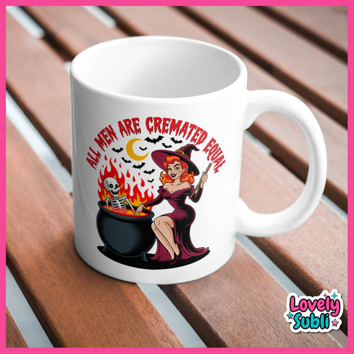 A white ceramic mug with a Halloween-themed graphic print, displayed on a wooden slatted surface. The graphic features a pin-up style witch sitting by a cauldron with a skeleton, flames, bats, and a crescent moon, with the text 'ALL MEN ARE CREMATED FOUR'.