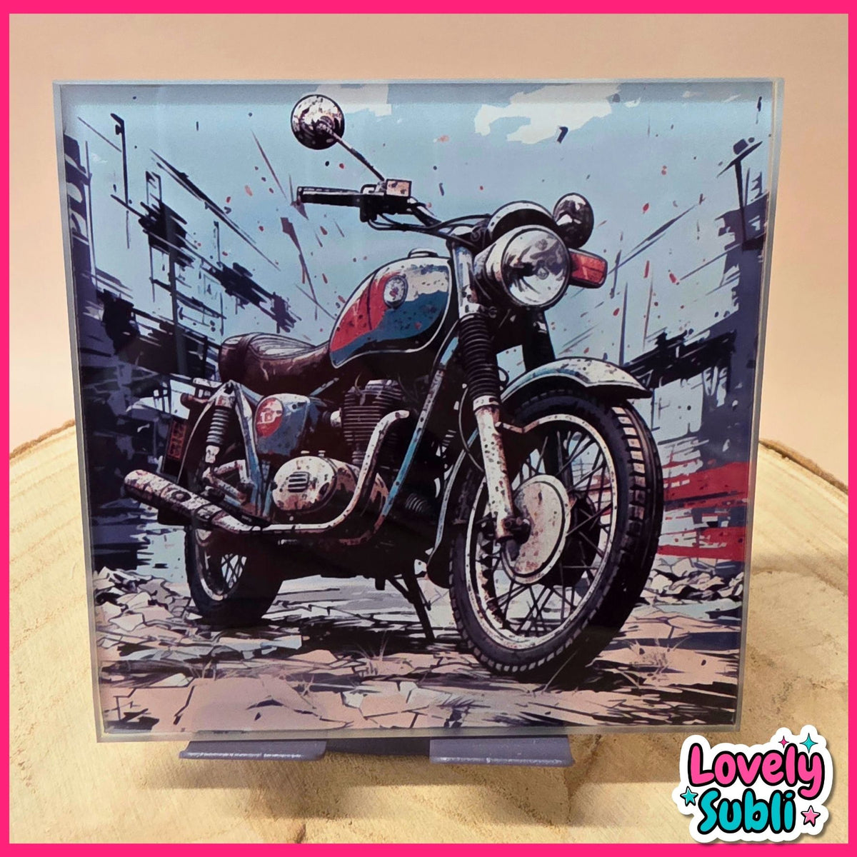 A square framed art print featuring a stylized illustration of a vintage motorcycle in a city street, displayed on a stand against a beige background with a pink border.