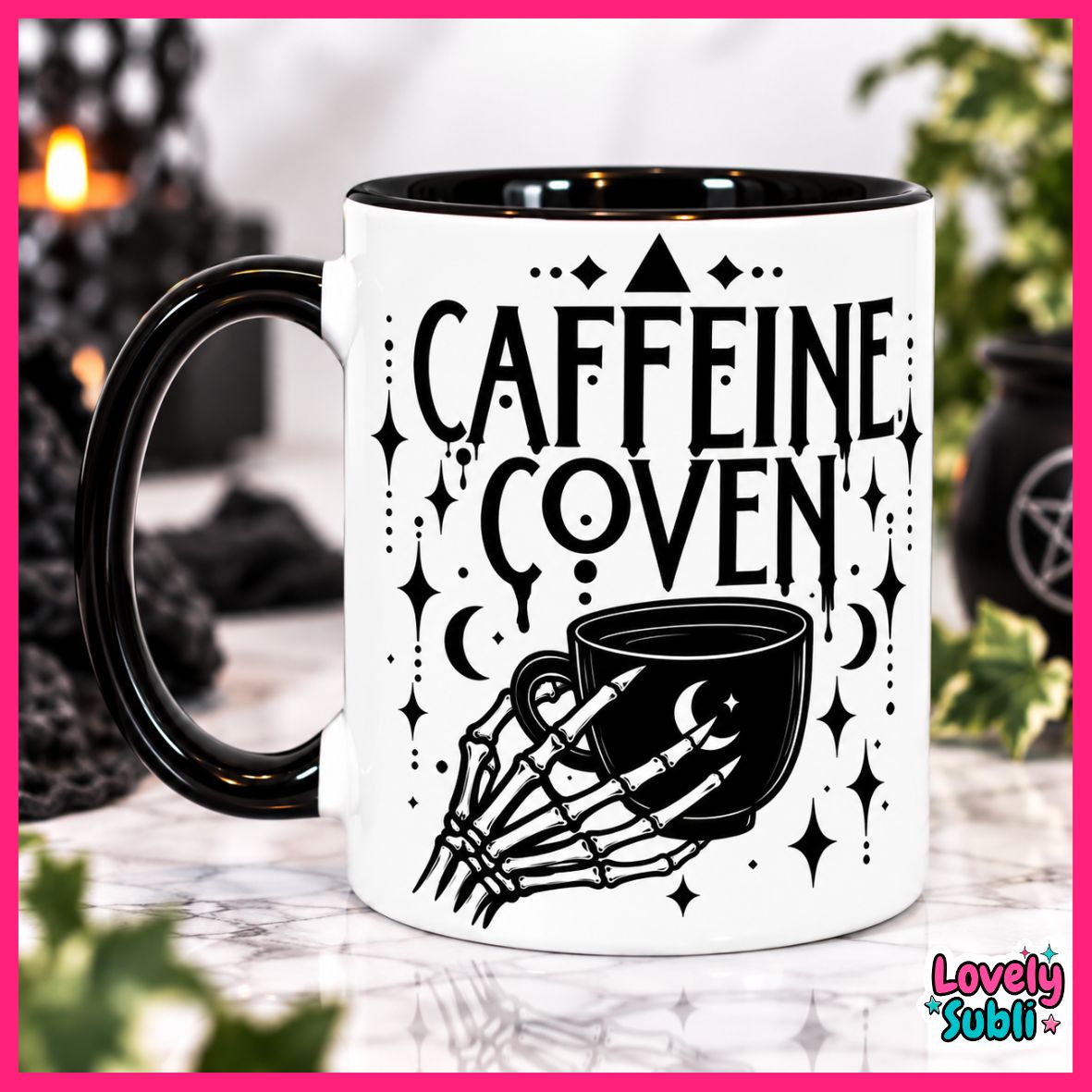 A white ceramic mug with a black handle and black interior, printed with the words 'CAFFEINE COVEN' and a skeletal hand holding a mug with moon and star details. The mug is photographed on a marble-like surface with a blurred dark background and greenery.