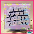 A square acrylic art print featuring the text 'what fresh hell is this?' in a bold, 3D bubble font with a pink-to-blue gradient. The background of the print has a pink grid pattern with yellow lemon slice motifs.