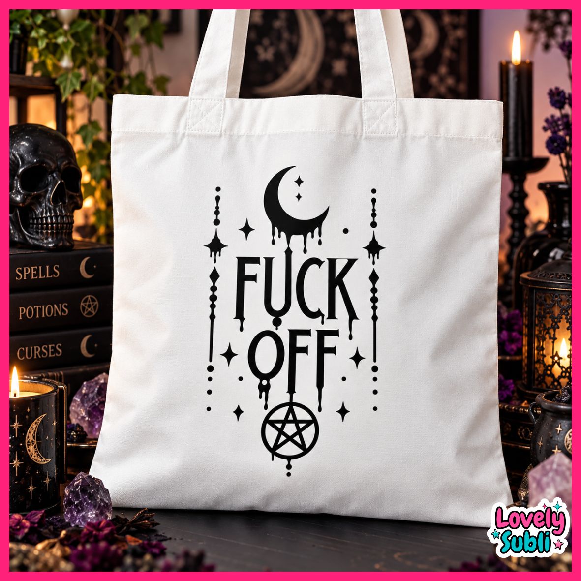 A white canvas tote bag with a black gothic-style graphic reading 'FUCK OFF' with a crescent moon, stars, and pentagram. The bag is displayed in a styled witch-themed setting with candles, a skull, and occult books.