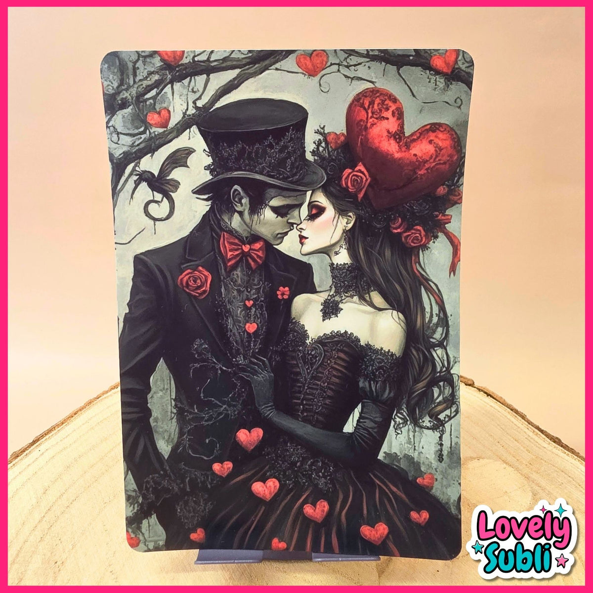A vertical art print featuring a gothic Victorian-style couple kissing, with red hearts, roses, and a bat against a pale background, displayed on a wooden surface with a pink border and a 'Lovely Subl' logo in the corner.