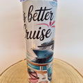 A white insulated tumbler with a travel-themed print that reads 'is better Cruise' in black script, featuring an illustration of a cruise ship, ocean waves, and beach accessories, standing on a round wooden slice against a plain light background.