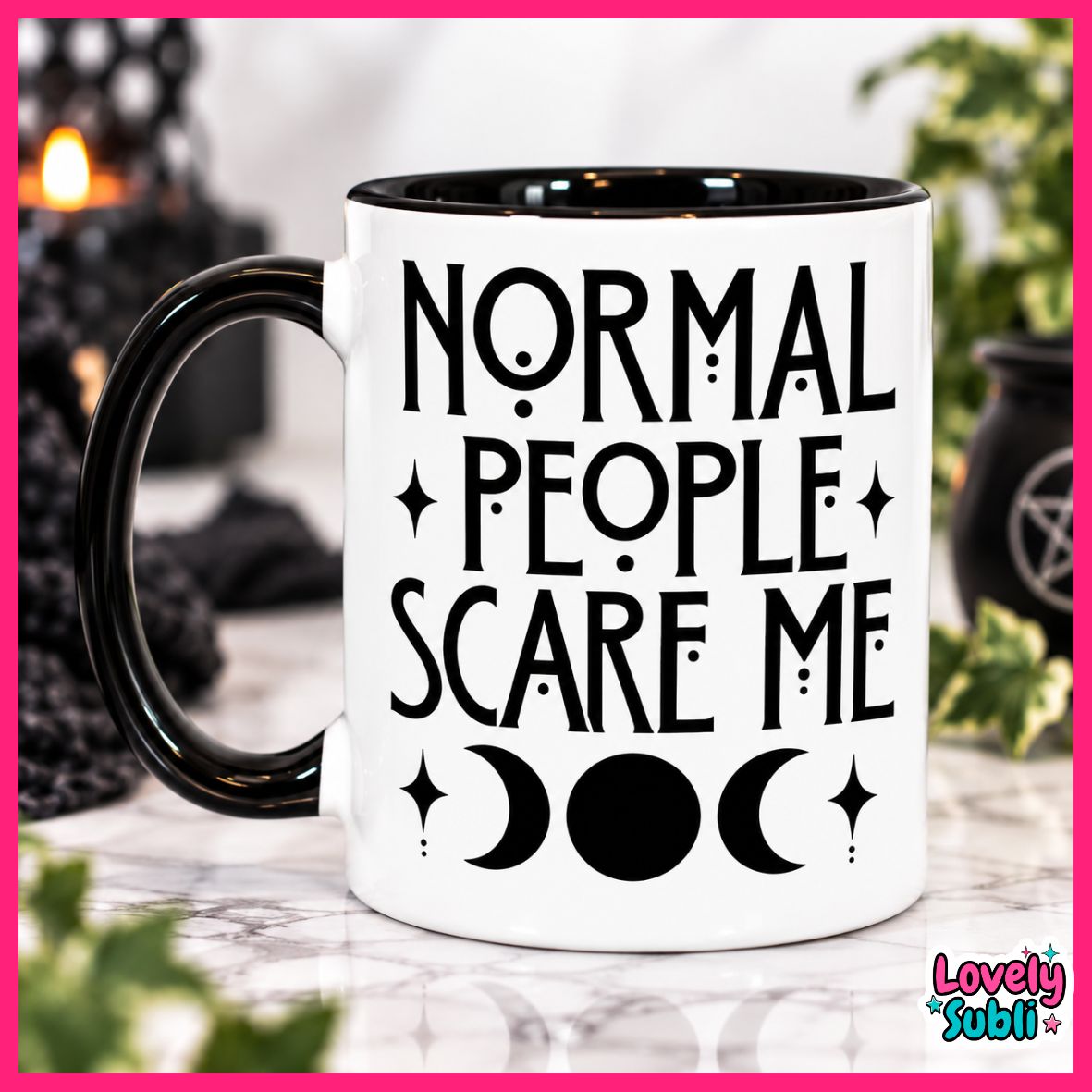 A white ceramic mug with a black handle and black interior, printed with the phrase 'NORMAL PEOPLE SCARE ME' in black lettering above moon and star symbols. The mug is photographed on a marble-like surface with blurred dark decorative objects and greenery in the background.