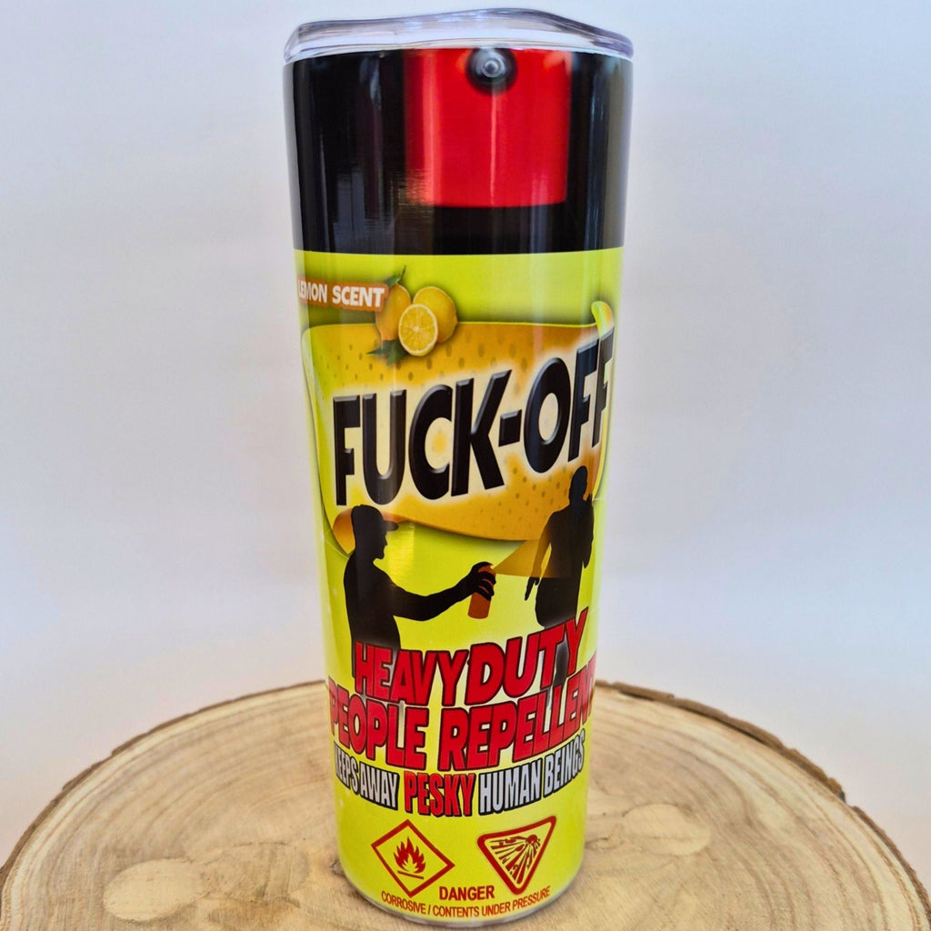 A can of 'FUCK-OFF' heavy duty people repeller spray, featuring a bright yellow label with black and red text, set on a wooden slice against a white background