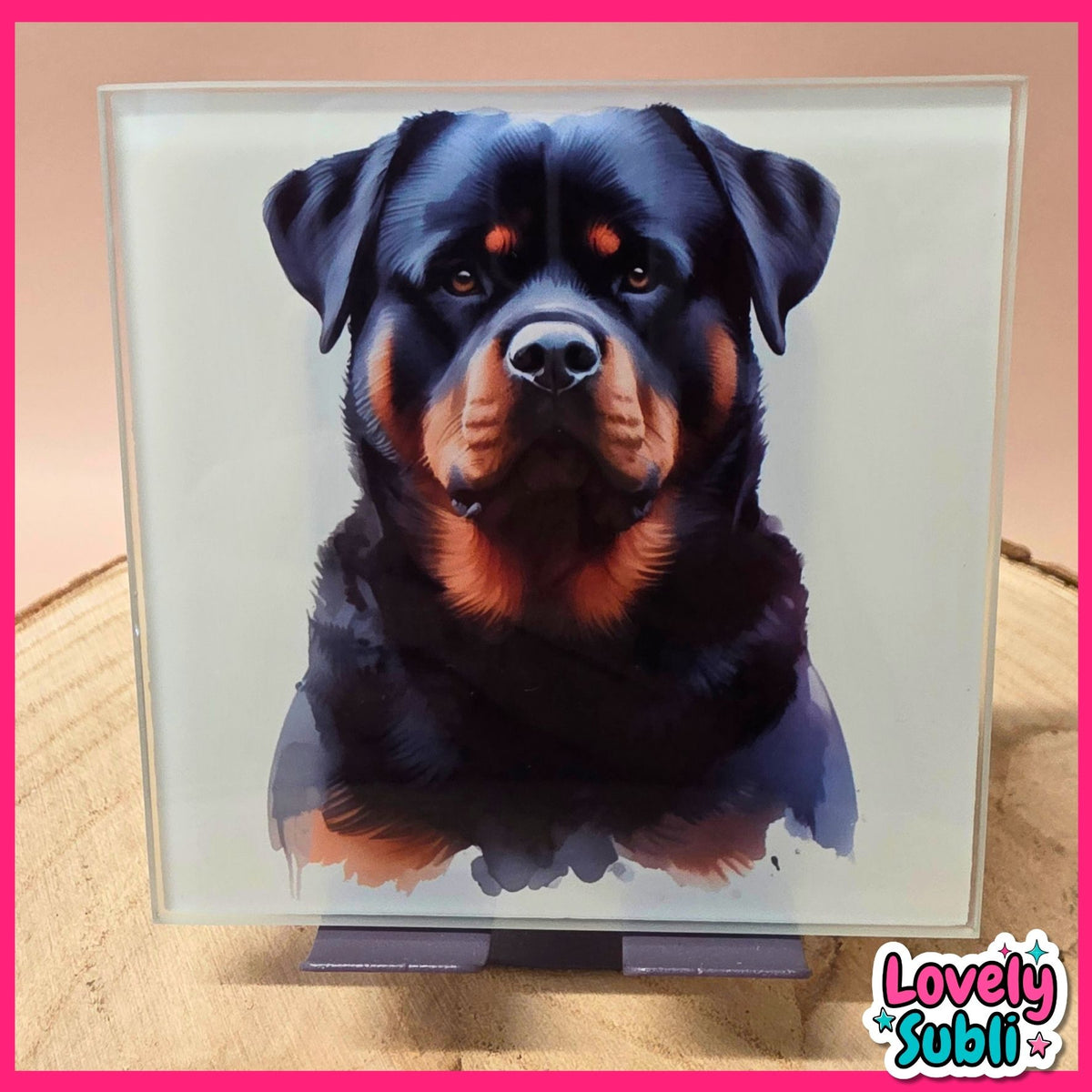 A square glass art print featuring a painted portrait of a Rottweiler dog, displayed on a small stand. The print is set against a light background with a pink border and a 'Lovely Subli' watermark in the bottom right corner.