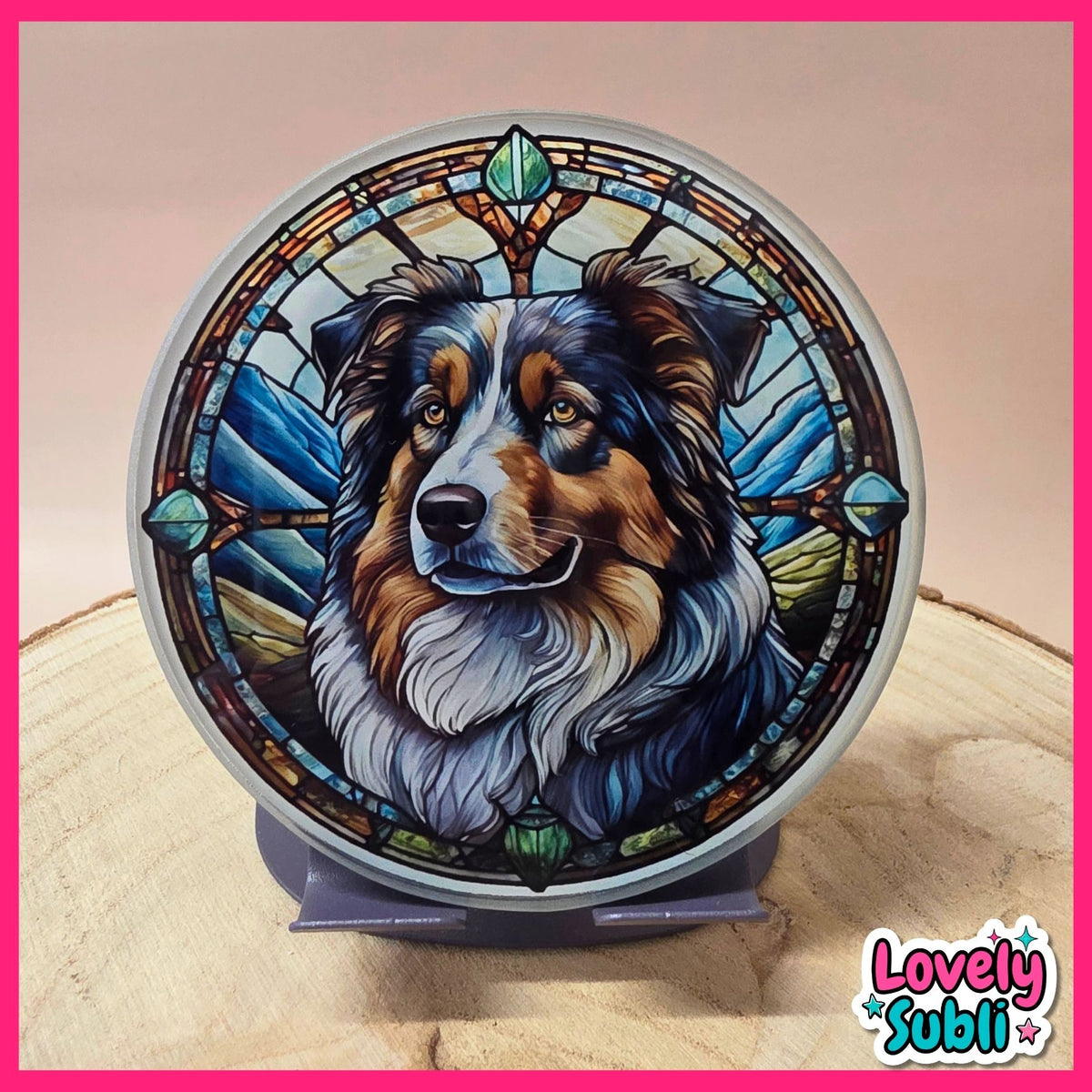 A circular decorative plaque or coaster featuring a stained-glass-style illustration of an Australian Shepherd dog, displayed on a small stand on a wooden surface. The design includes blue, green, brown, black, and white tones.