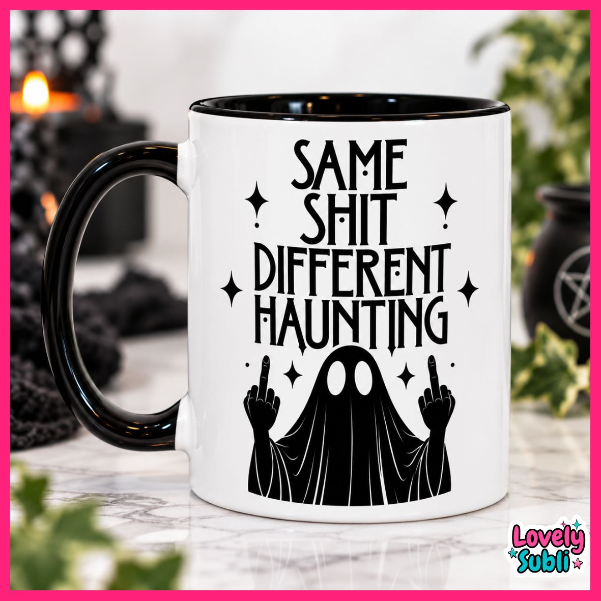 A white ceramic mug with a black handle and black interior, printed with the phrase 'SAME SHIT DIFFERENT HAUNTING' above a black ghost figure making middle fingers. The mug is photographed on a marble-like surface with a blurred Halloween-themed background, framed by a bright pink border with a 'Lovely Subli' logo in the lower right.