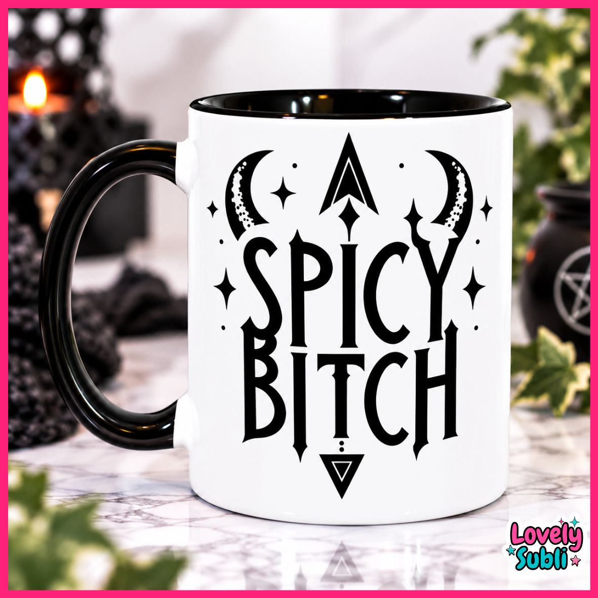 A white ceramic mug with a black handle and black interior, featuring the text 'SPICY BITCH' in a gothic font with crescent moons, stars, and an arrowhead graphic. The mug is displayed on a marble surface with a blurred background containing candles and greenery.