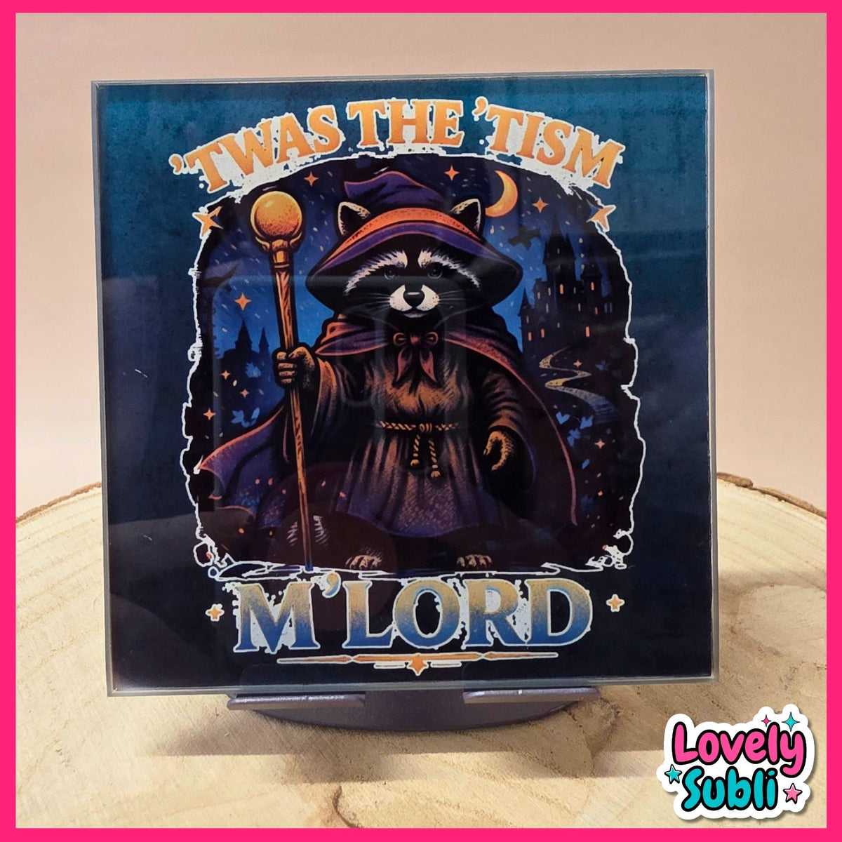 A square printed sign or album-cover-style artwork on a small stand, featuring a raccoon dressed as a wizard holding a staff against a dark blue night scene. The text reads "'Twas the 'Tism" at the top and "M'Lord" at the bottom.