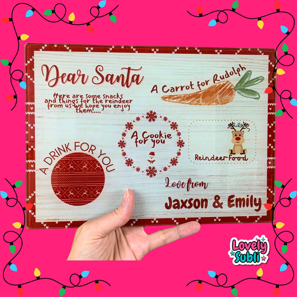 A hand holds a personalized Christmas letter board designed to look like rustic white wood, featuring red borders, a carrot illustration, a reindeer cookie, a knitted drink coaster, and customizable text. The background is bright pink with decorative string lights and a 'Lovely Subli' brand logo in the corner.